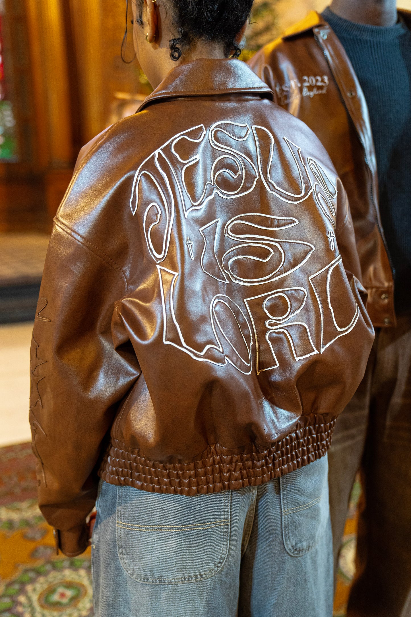 “Jesus Is Lord” (J.I.L) Vegan Leather Jacket in Cocoa Brown.